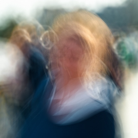 Portrait en longue exposition d'une femme blonde, cheveux emportés par le mouvement