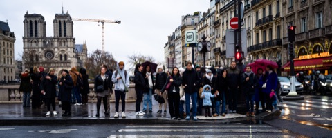 Piétons attendant devant Notre-Dame de Paris sous un ciel d'hiver
